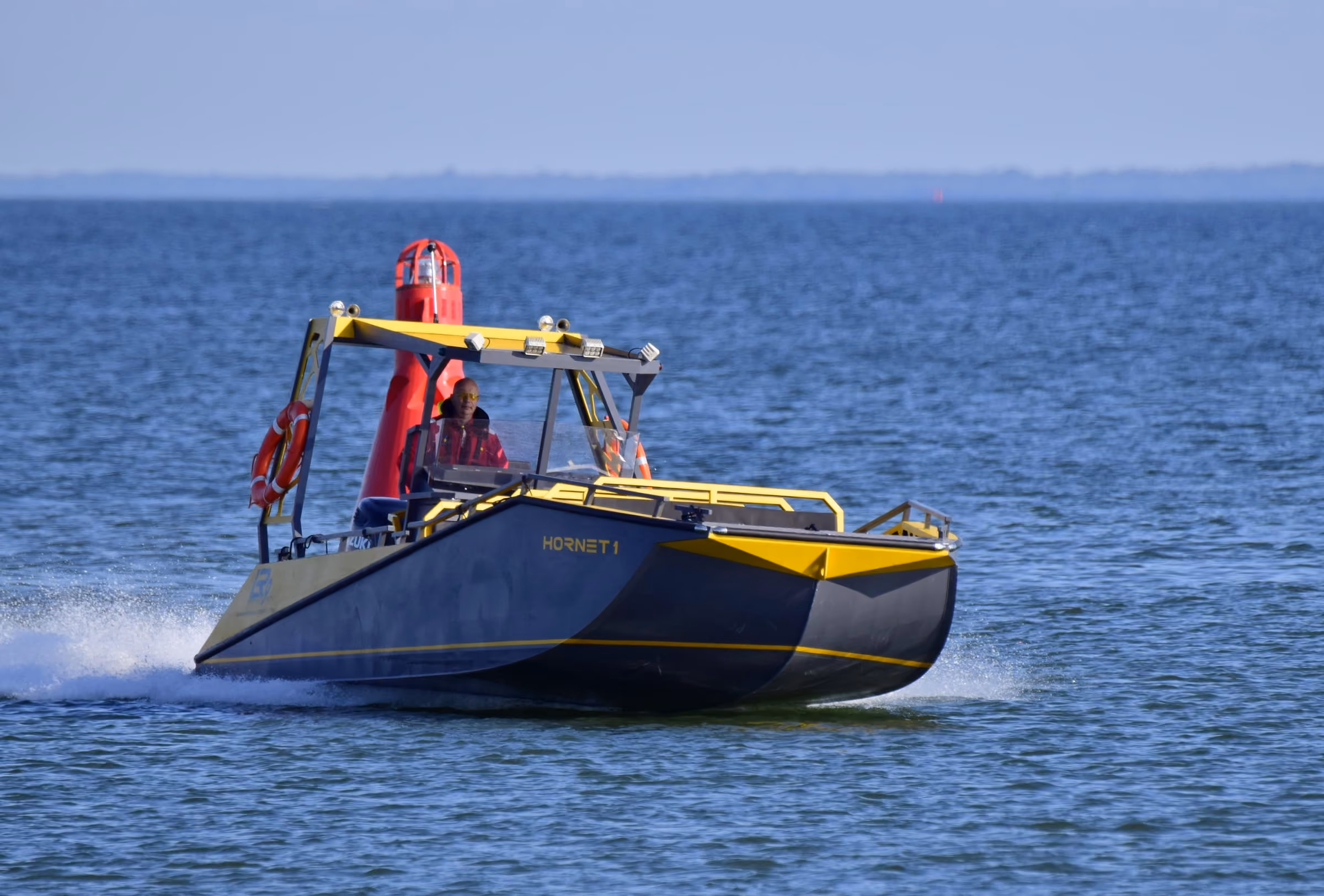 Bow quarter view of the LR9 Safari underway, showing the open forward passenger deck and the raised helm position behind it