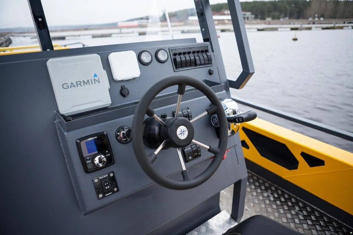 LR9 Safari helm console with a Garmin chartplotter, wheel, engine controls and switch panel on a bare aluminium dash